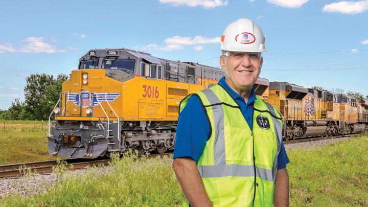 Jim Vena standing beside a yellow Union Pacific locomotive