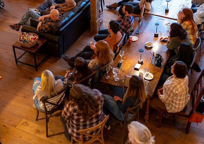 The JK Communications team gathered around a long wooden table during an agency meeting