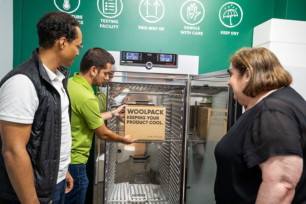 Joanne Howarth and two colleagues inspecting a WOOLPACK carton in a temperature-testing chamber