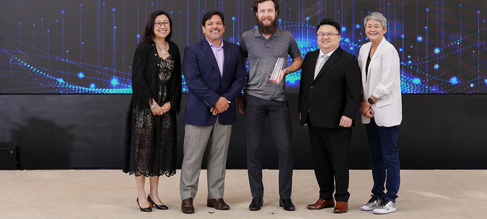 Joanne Wong standing with LogRhythm colleagues and a partner award recipient at the 2023 Asia-Pacific Partner Tech University event
