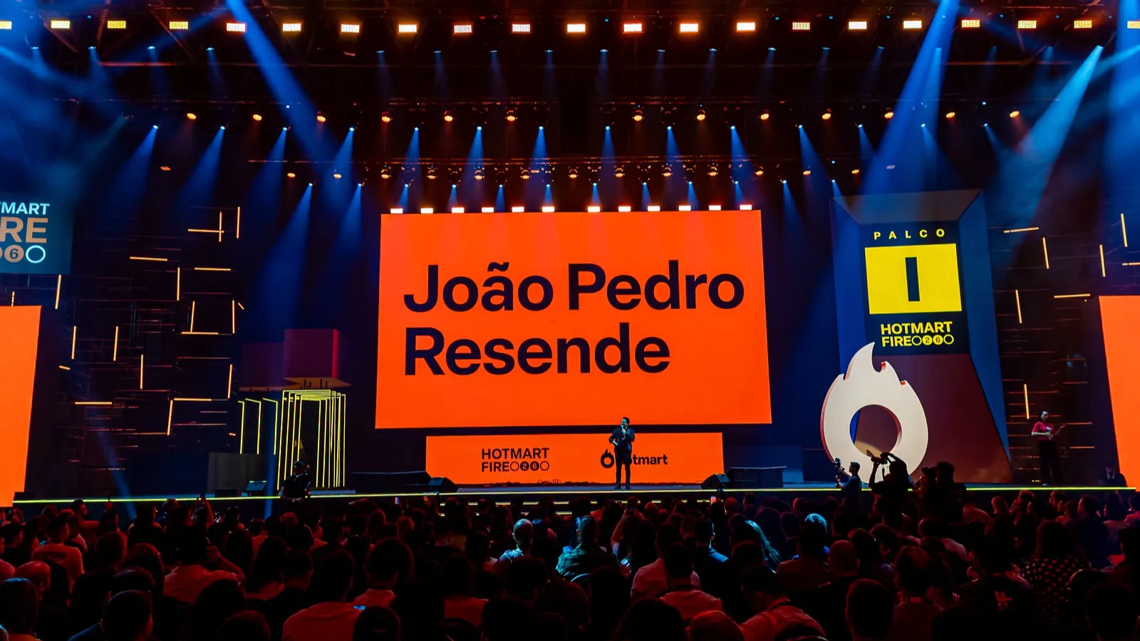João Pedro Resende speaking on a brightly lit stage at Hotmart FIRE 2026