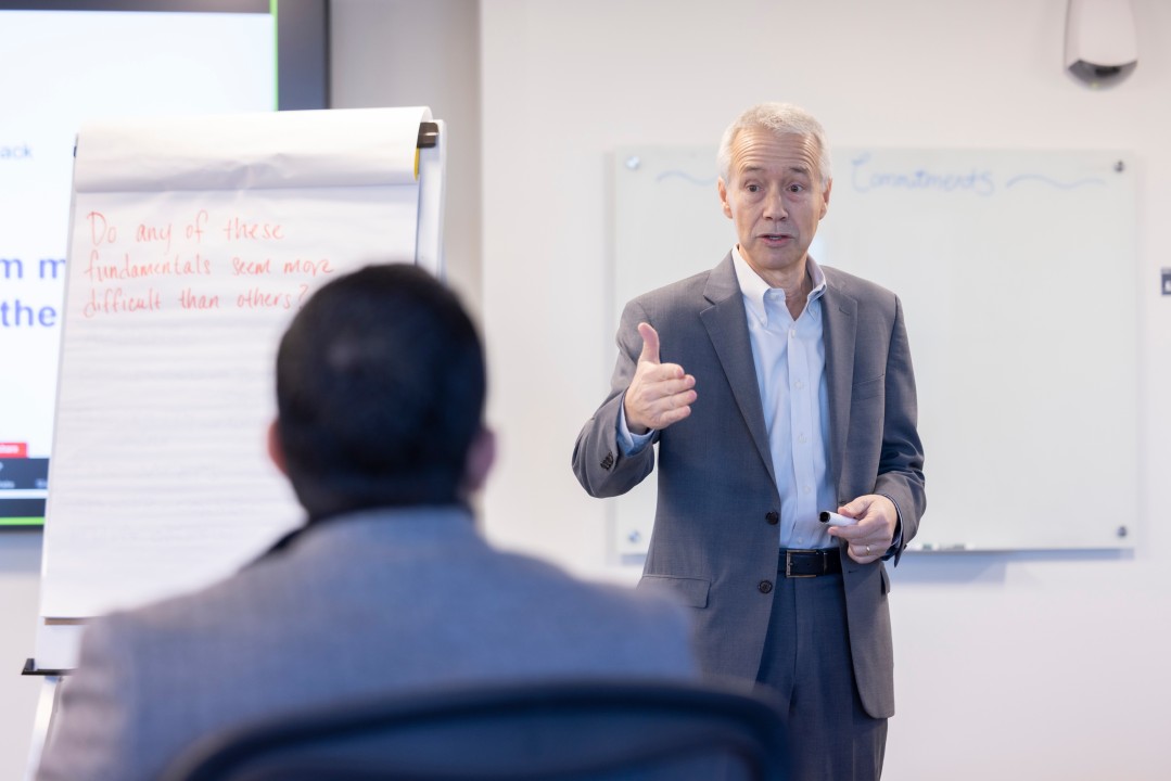 Joaquin Duato speaking to colleagues in a classroom beside a flip chart