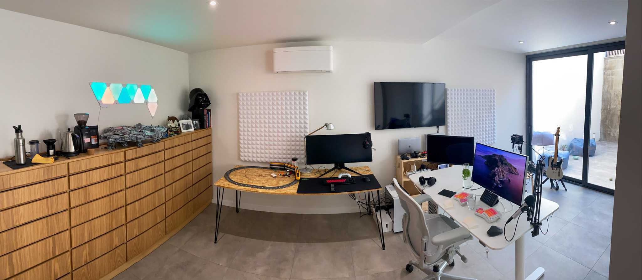 Two desks, screens and a long wooden cabinet in van der Voort’s home office