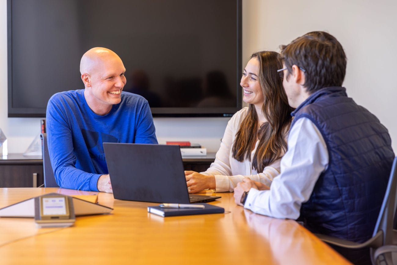 Ben Hodson, at left, talking with Mainsail colleagues around a conference table