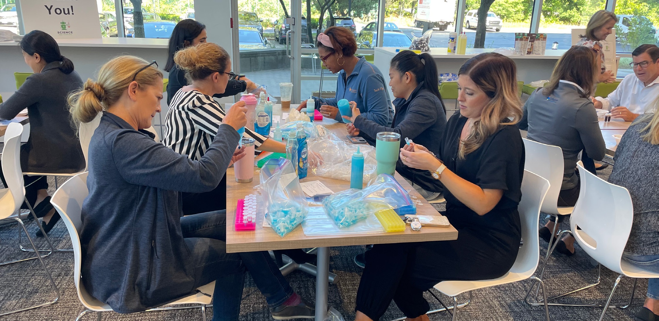 Collegium employees seated around tables preparing materials during a company service activity