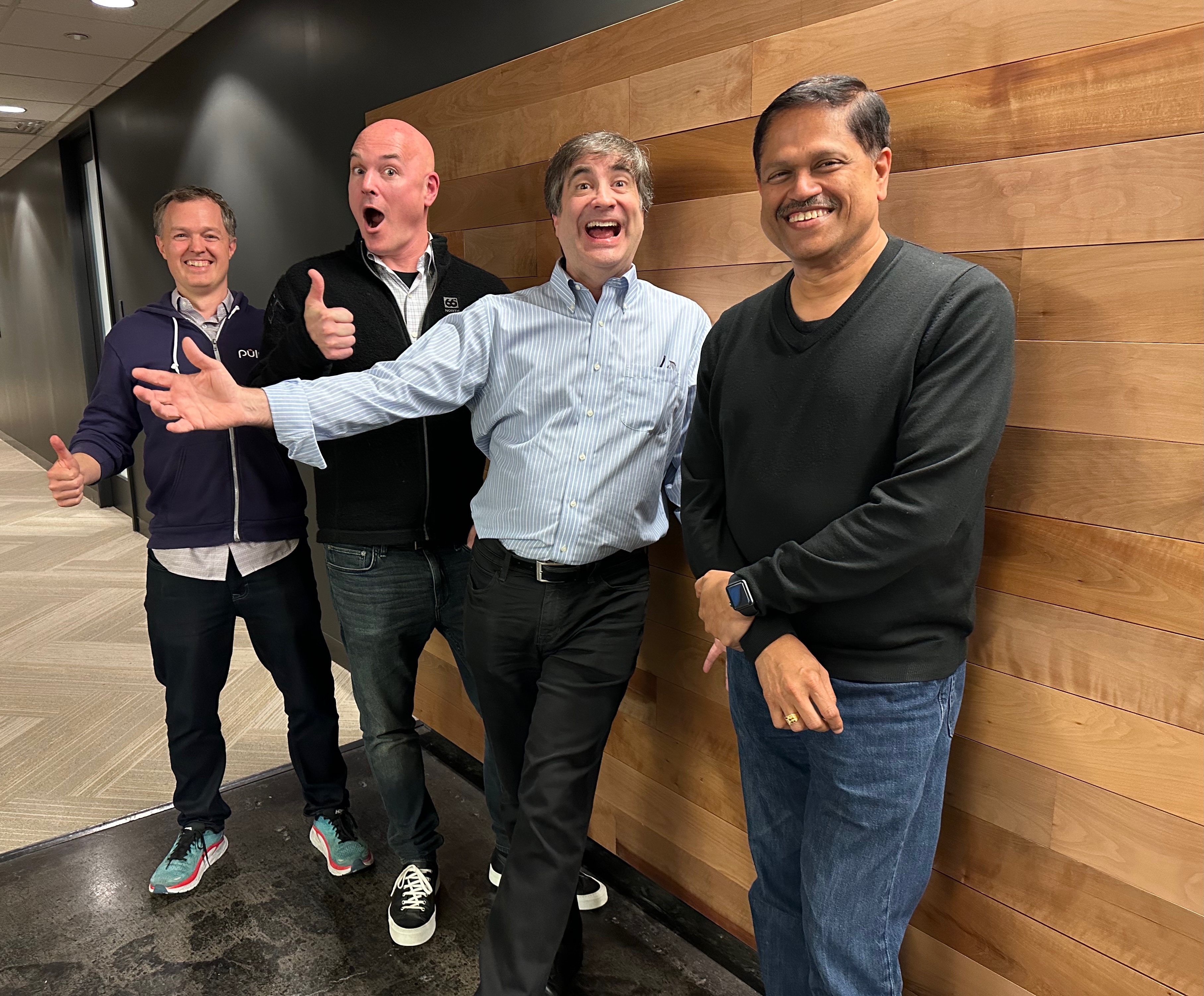 Luke Hoban, Joe Duffy, Eric Rudder, and S. Somasegar pose together in an office hallway