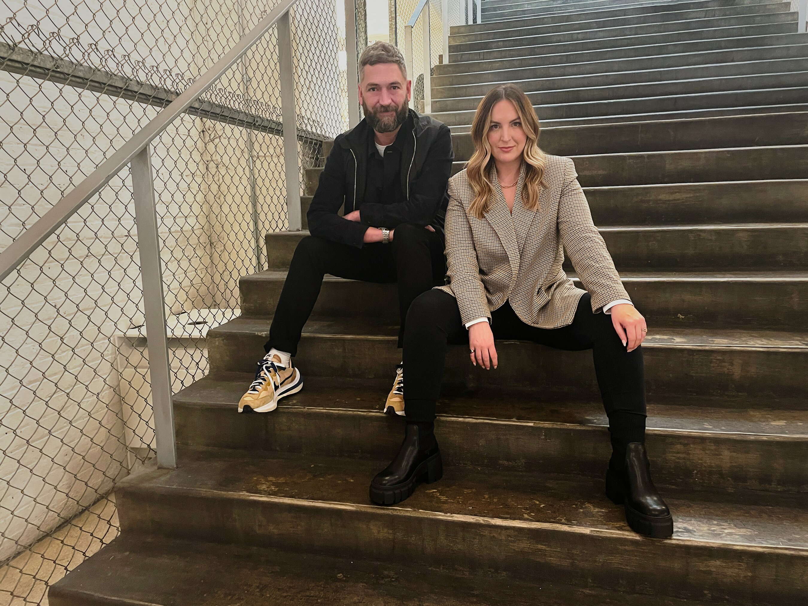 Joe Mackay-Sinclair and Sarah Jenkins sitting on a staircase for The Romans’ New York launch