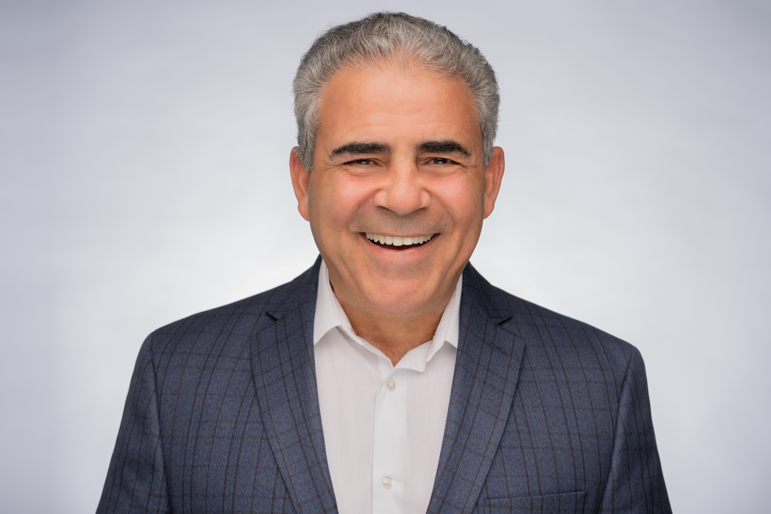 Joe Urbay smiling in a studio photograph