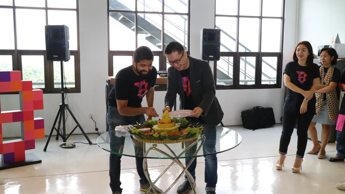 Joe Wadakethalakal and Danny Purnomo cutting a tumpeng at Brilio’s office celebration