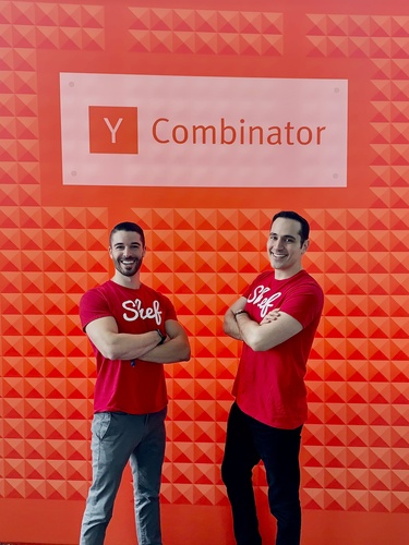 Joey Grassia and Alvin Salehi wearing red Shef shirts in front of a Y Combinator sign