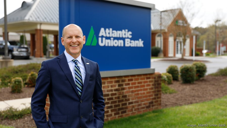 John Asbury standing beside an Atlantic Union Bank sign outside a branch