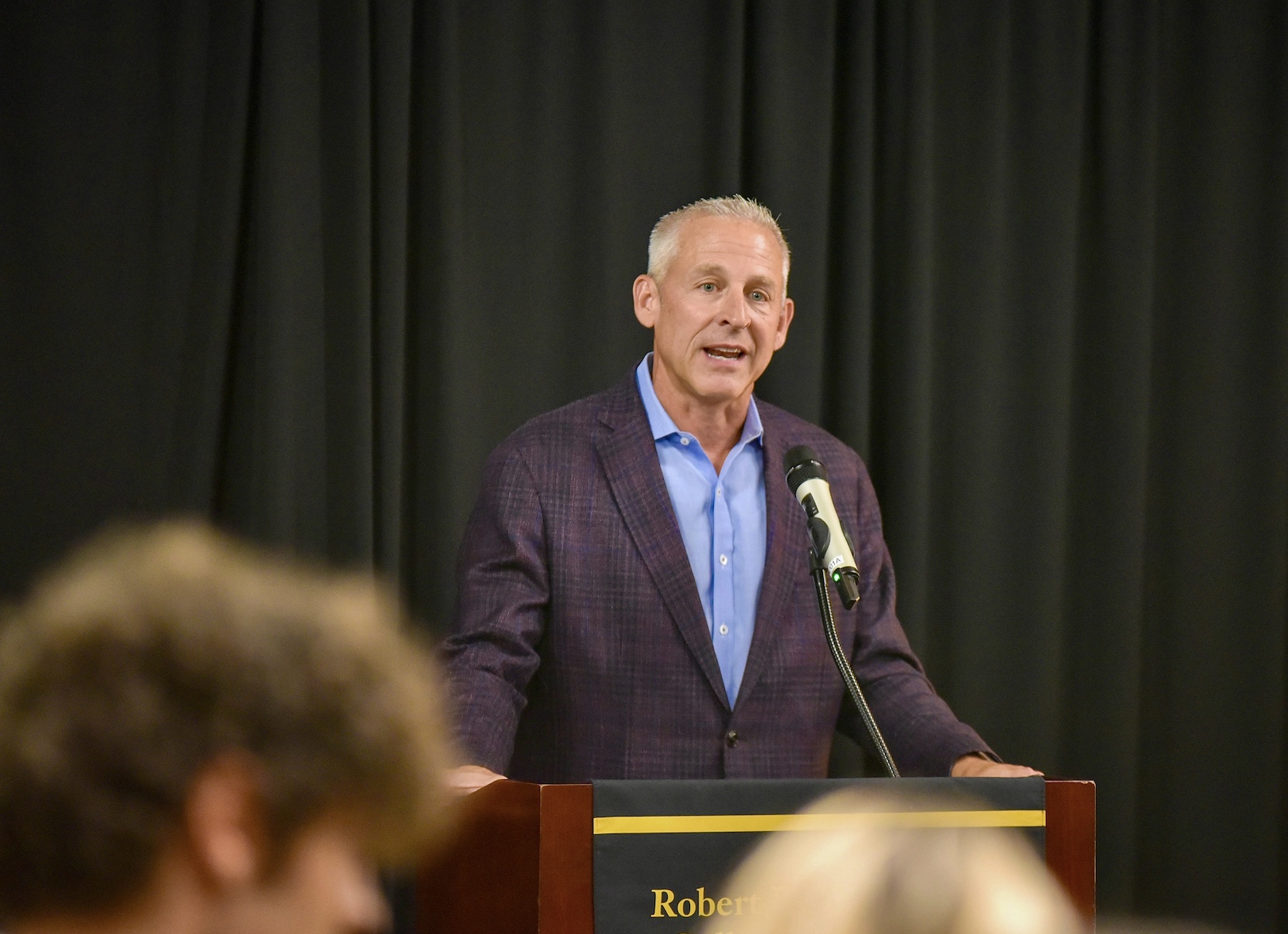 John Brase speaking at a lectern at the University of Missouri