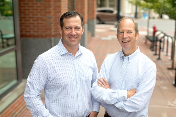 Keen Decision Systems co-founders Greg Dolan and John Busbice standing together outdoors