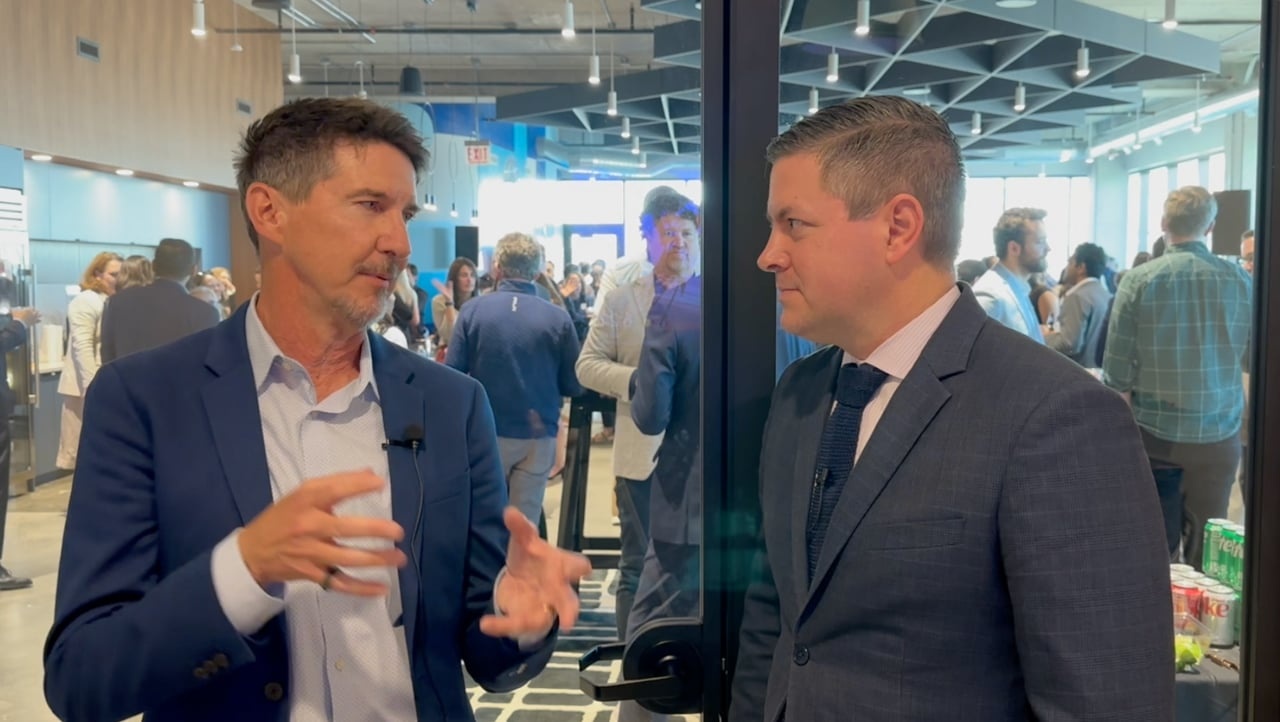 John Flavin, on the left, speaking during an interview at a Chicago event