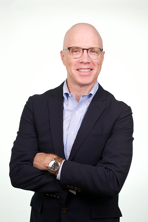John Gallagher in a dark jacket and light blue shirt, photographed for City and State New York's 2021 Pride Power list