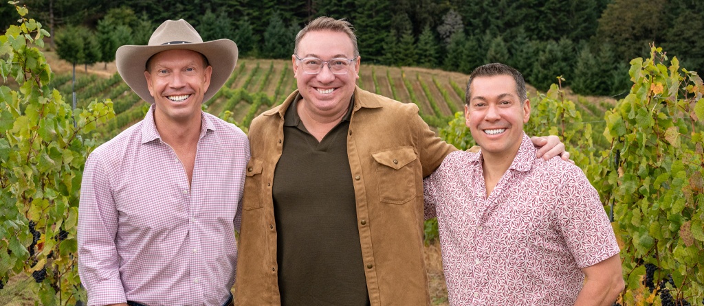 Tres Colline proprietors Cross Moceri, Frank Busch and John Griggs standing together among vineyard rows, with Griggs at right