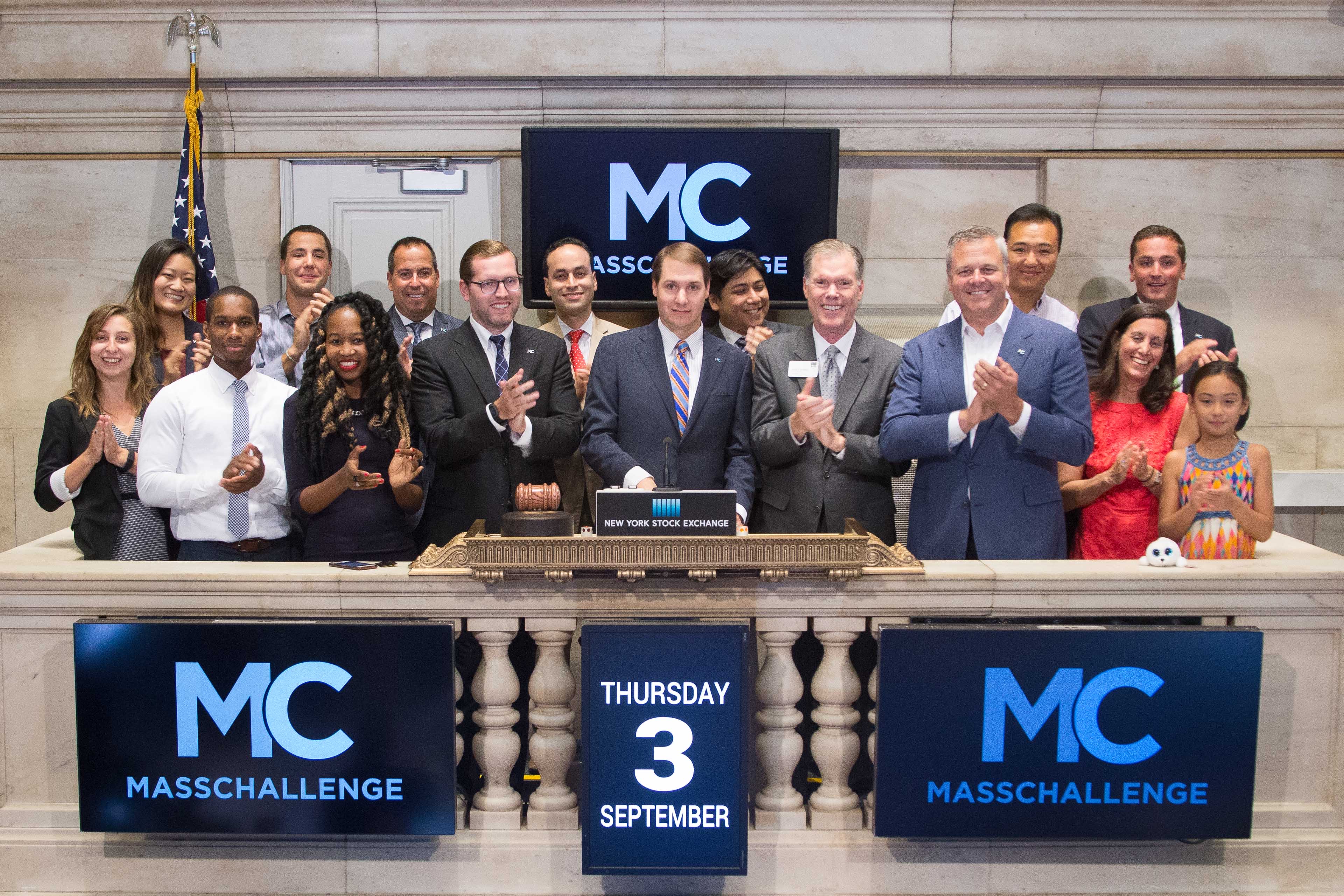 John Harthorne at the center of a MassChallenge group on the New York Stock Exchange bell podium