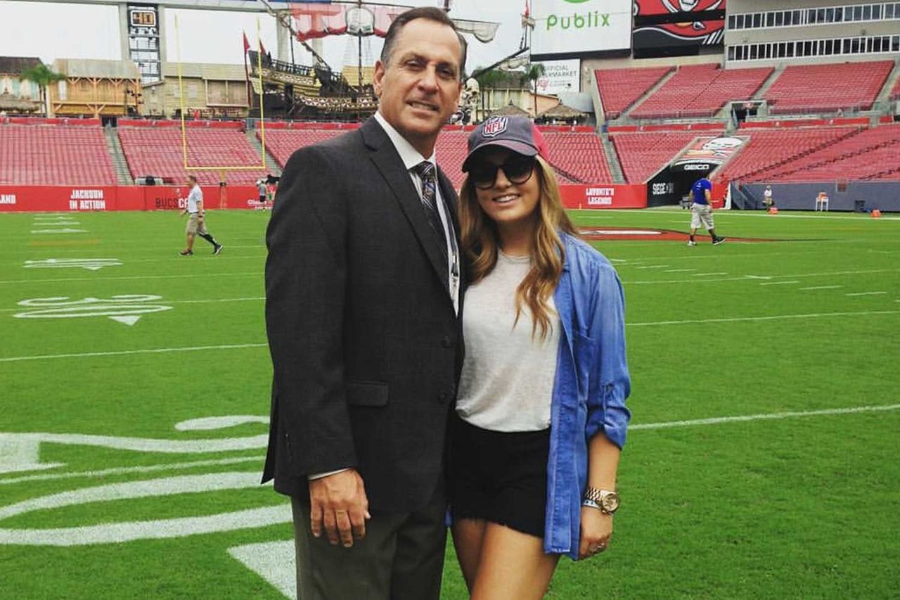 John Hussey and his daughter Emily standing together on an NFL field