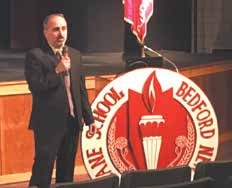 John LaPlaca speaking into a microphone at a Bedford schools safety forum
