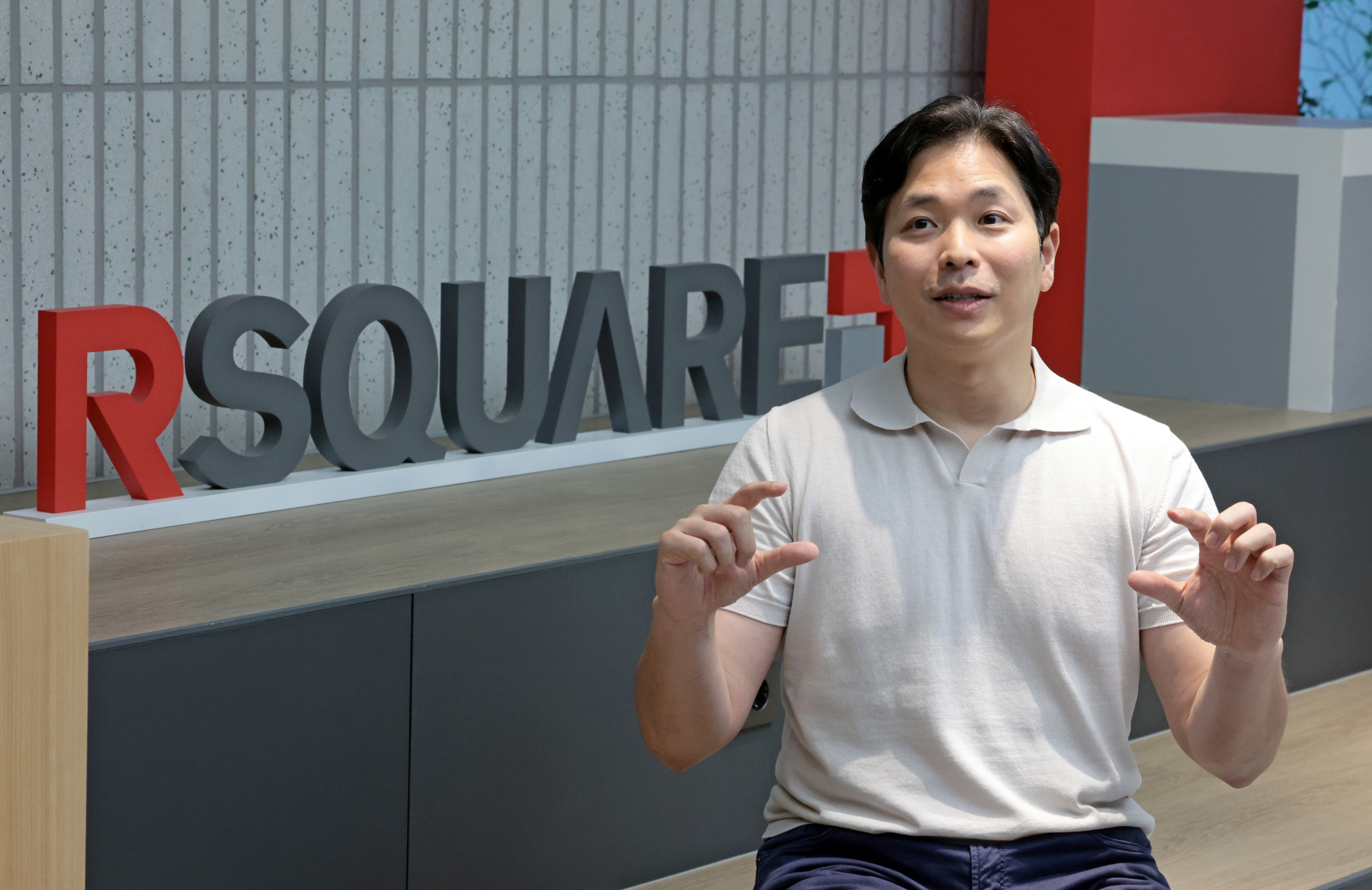 Johnwoo Lee gesturing during an interview at an RSQUARE office