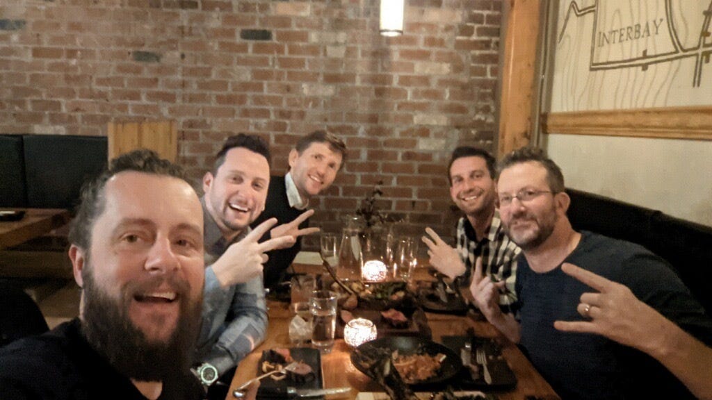 John Linden at the right of a restaurant table with Jamie Jackson and members of the Struck Capital team