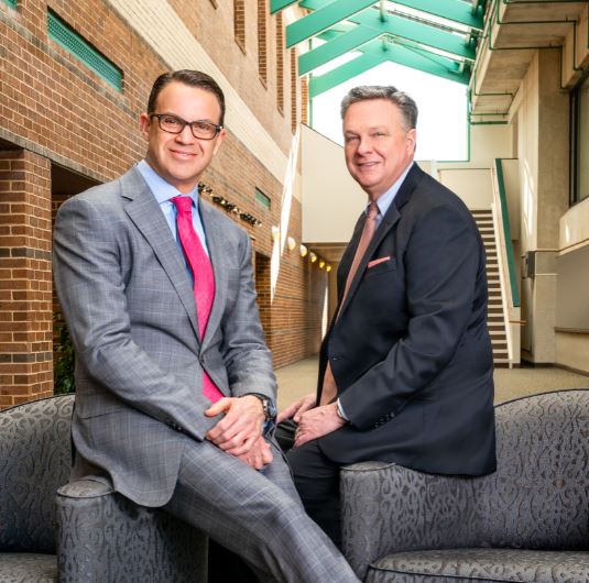 John Marchioni, at left, seated beside Greg Murphy in a bright brick-lined atrium
