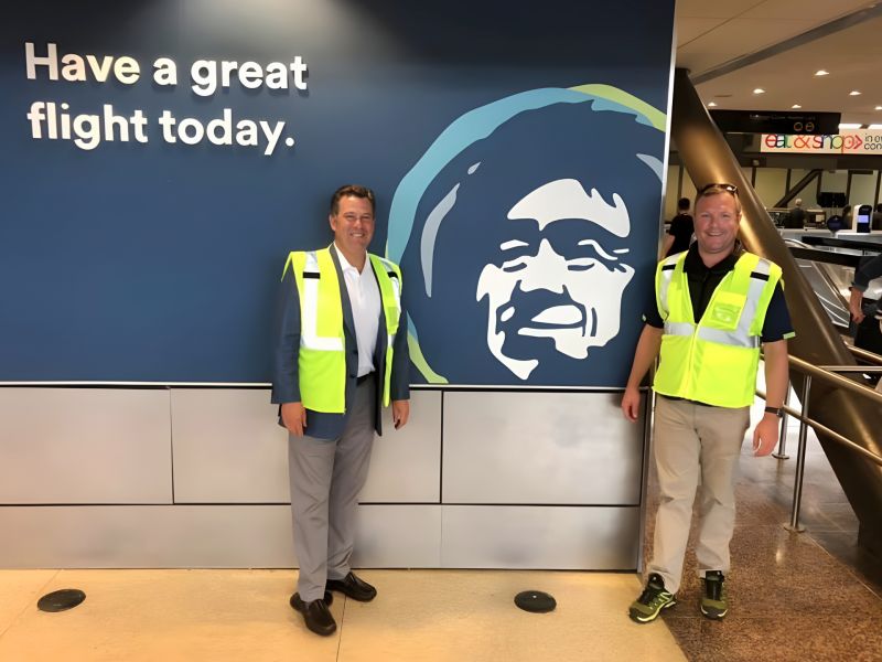 Two men in fluorescent safety vests during an airport visit