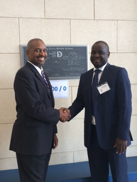 Principal Dennis Taylor, left, and John Olajide shake hands at Kennedy-Curry Middle School
