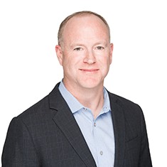 John O'Reilly in a dark jacket and pale blue shirt