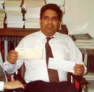 John Parris holding a document in an archival photograph from the June 1995 basement beginnings of Smartronix