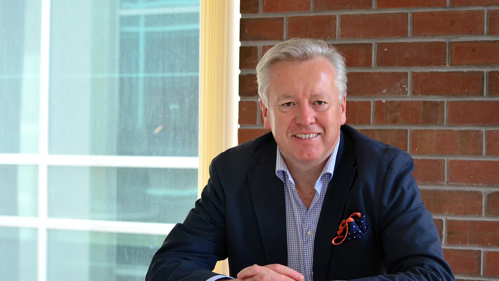 John Saunders seated at a table in a bright office