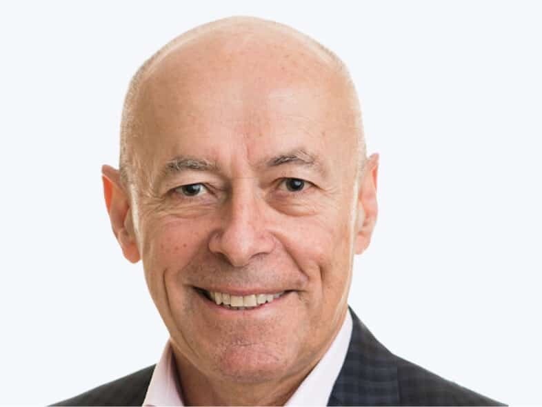 John Schwarz smiling in a checked jacket