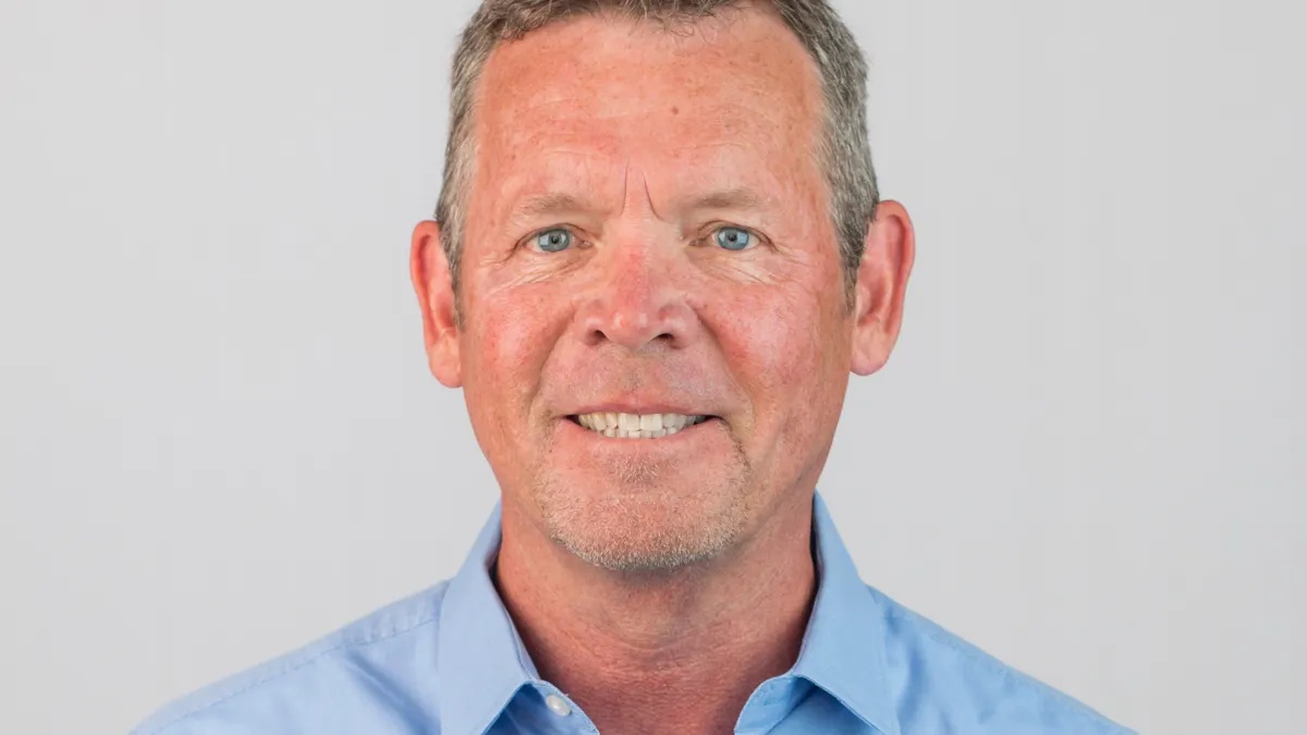 John Sheridan in a light blue shirt, photographed for a press interview