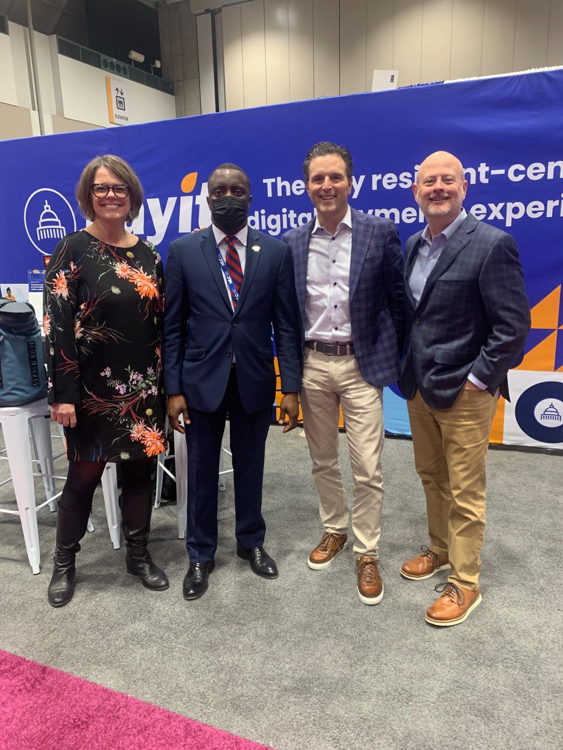 Kelly Davis-Felner, Jermaine Reed, John Thomson and Mike Plunkett at the PayIt booth at the 2022 National League of Cities City Summit.