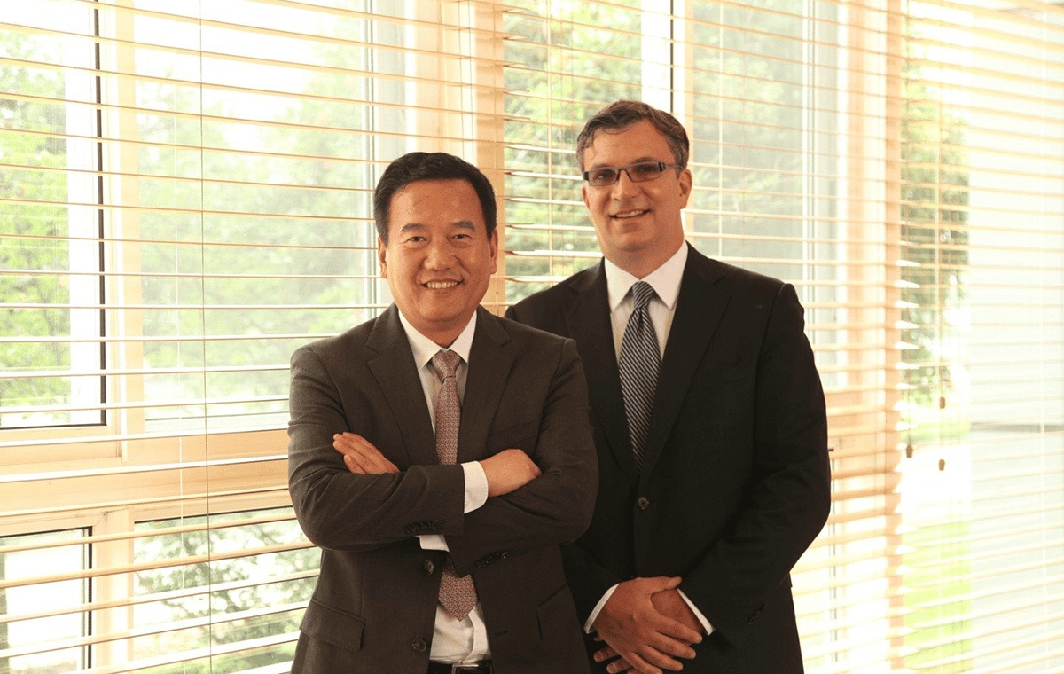 Xiaodong Wang, left, and John Oyler standing together beside a window