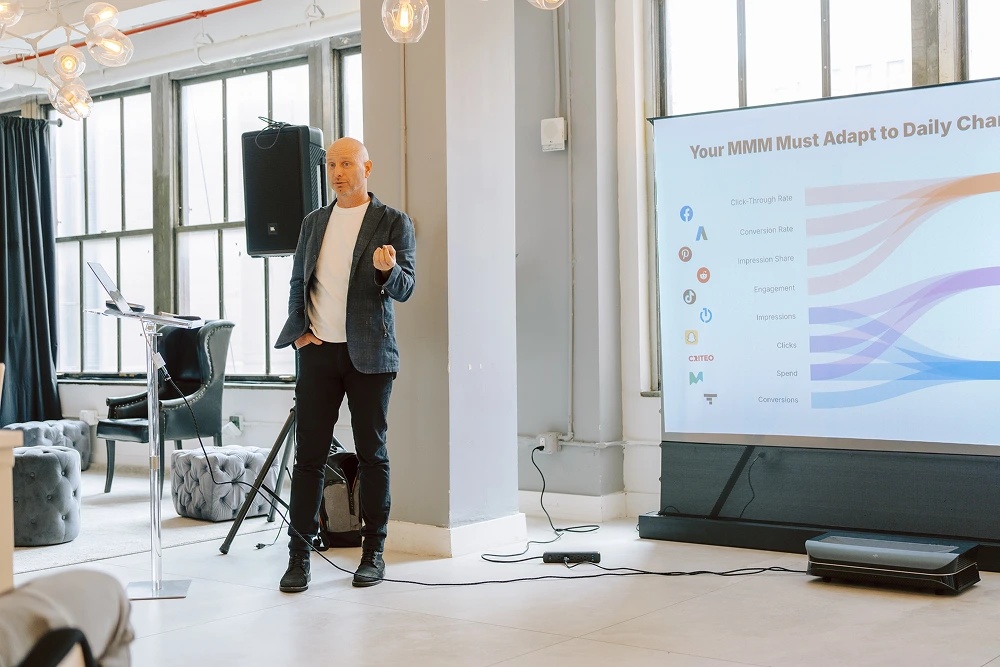 John Wallace speaking beside a presentation at LiftLab’s New York customer forum