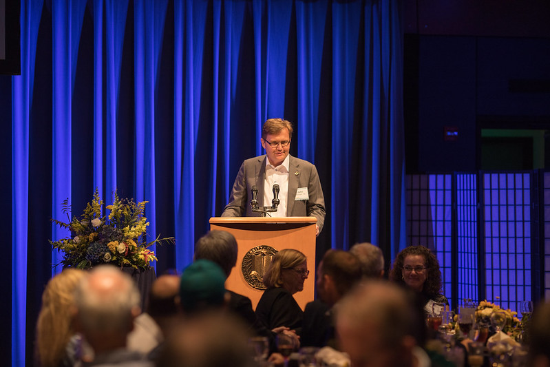 John Wasson at a lectern emceeing a UC Davis event