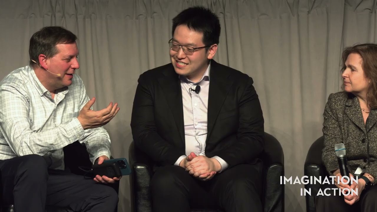 Johnny Ho seated between two interviewers during an Imagination in Action conversation at MIT