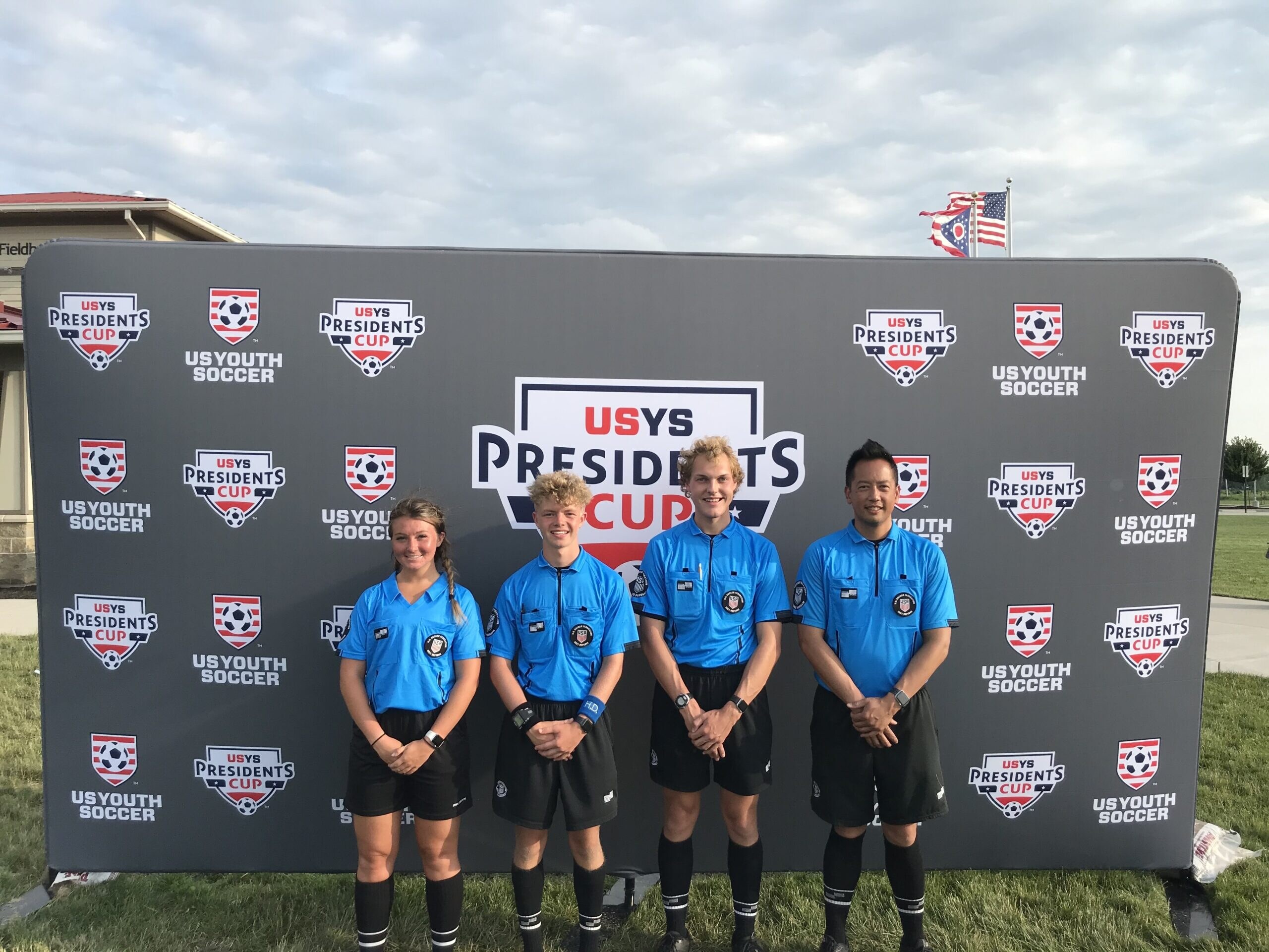Johnny Le and three fellow referees in blue uniforms at the US Youth Soccer Presidents Cup