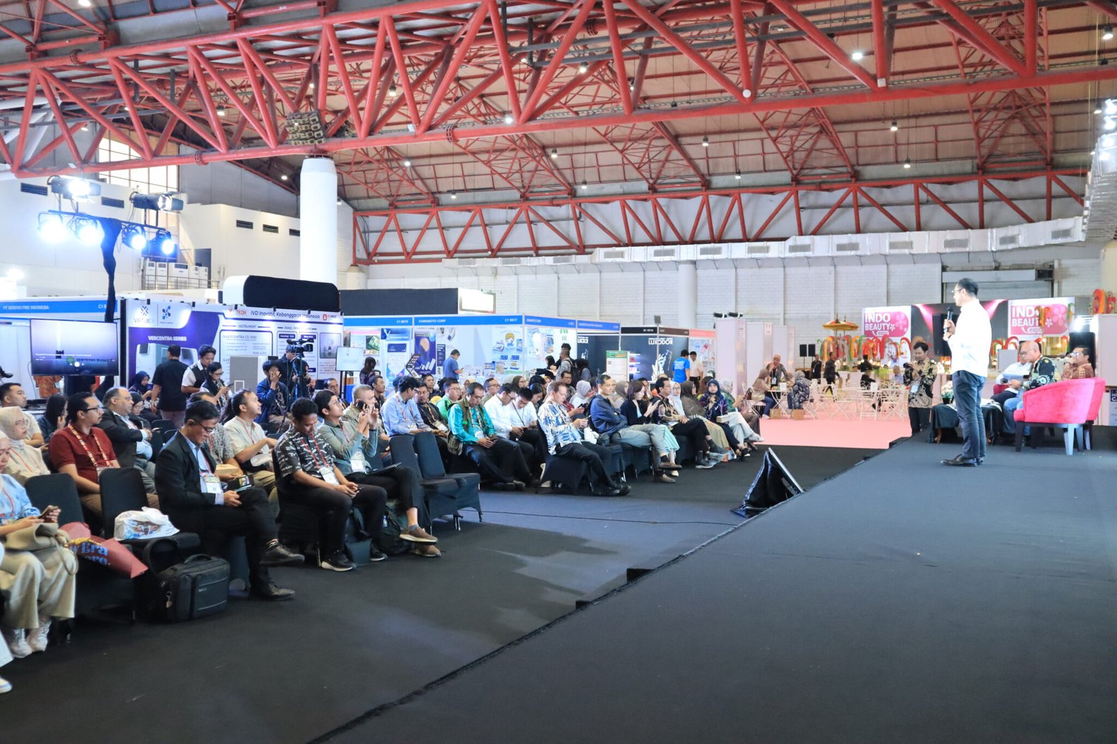 Johnson Zhang speaking to a seated audience at an industrial symposium in Jakarta