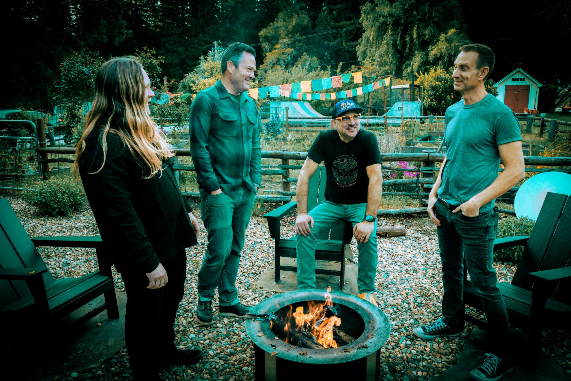 Time Spent Driving gathered outdoors around a fire pit, with trees and chairs behind them