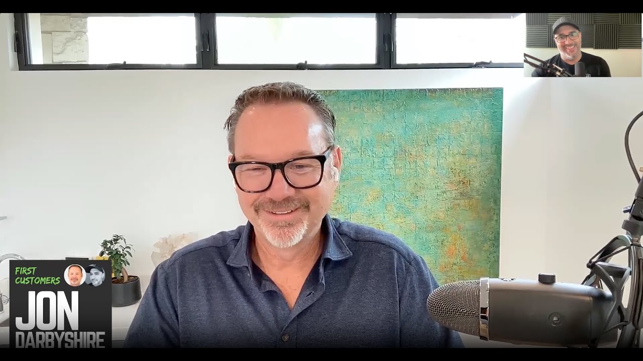 Jon Darbyshire speaking into a microphone during his First Customers video interview