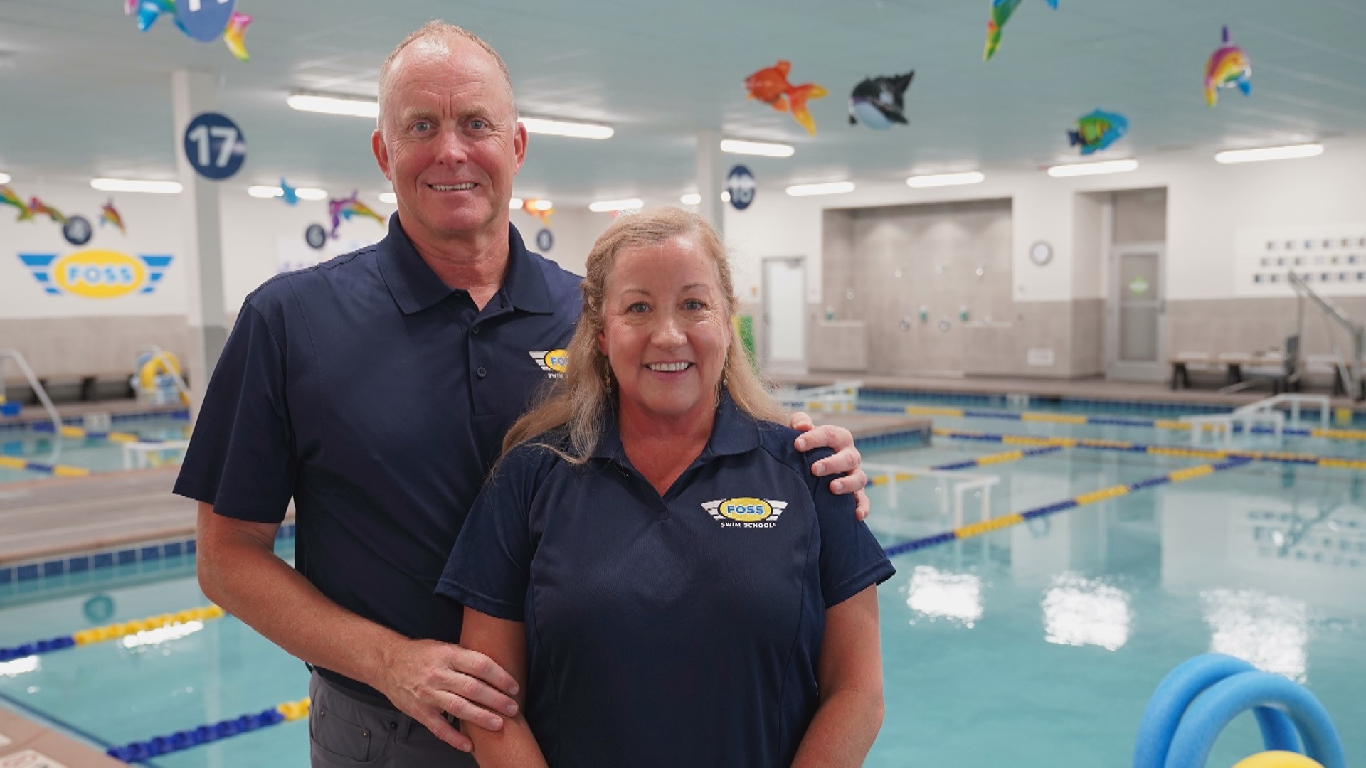 Jon and Susan Foss standing together beside an indoor teaching pool