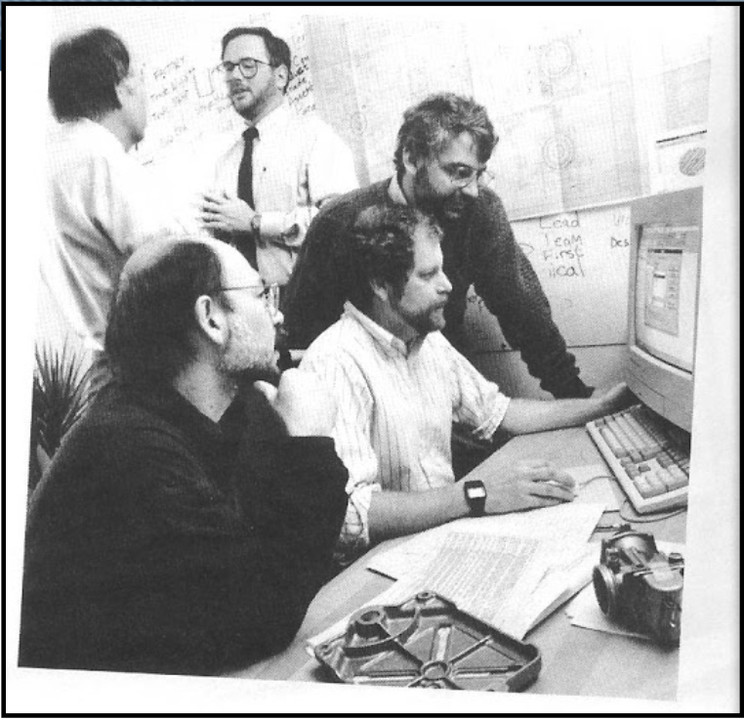 Five SolidWorks founders gathered around a desktop computer in 1994