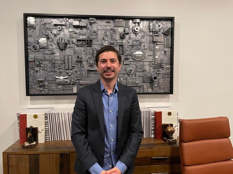 Jon Karafin seated in front of bound patent volumes at Light Field Lab