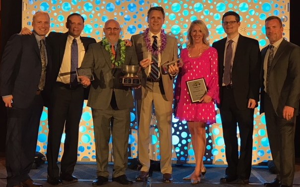 Seven people at a TWO MEN AND A TRUCK awards event; Jon Nobis stands second from right.
