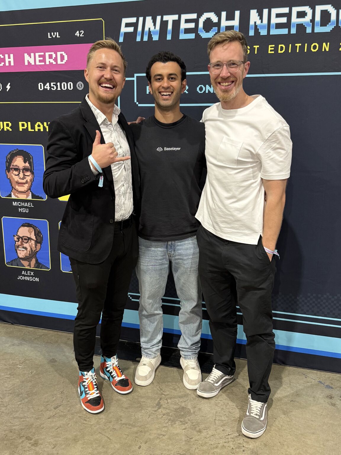 Jonathan Awad, center, smiling with two fintech colleagues at Fintech NerdCon