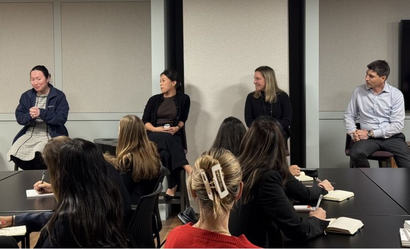 Jonathan Bilzin, seated at right, and TowerBrook colleagues speak with University of Michigan students in a meeting room.