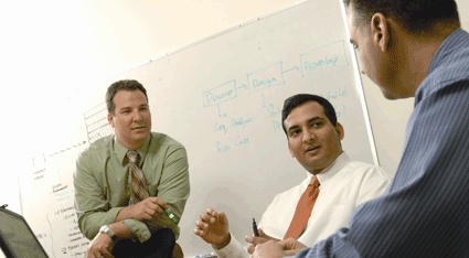 Jonathan Brassington, seated in the middle, takes part in a discussion beside a whiteboard