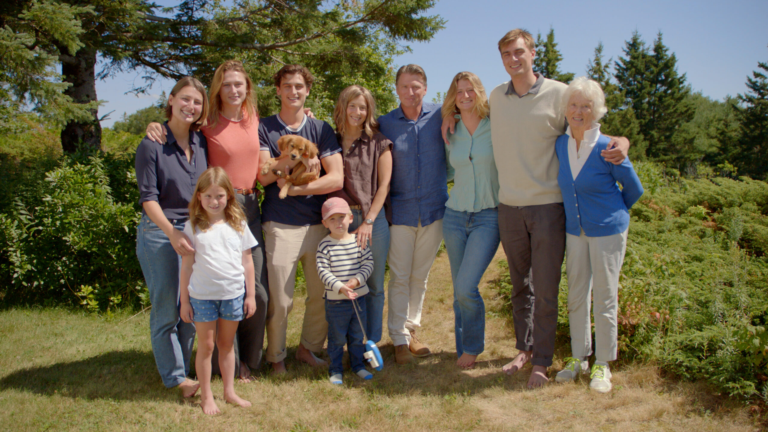 Jonathan Bush standing outdoors with his family and a small dog